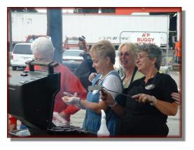 Smiling volunteers ready to serve you a BBQ delight!